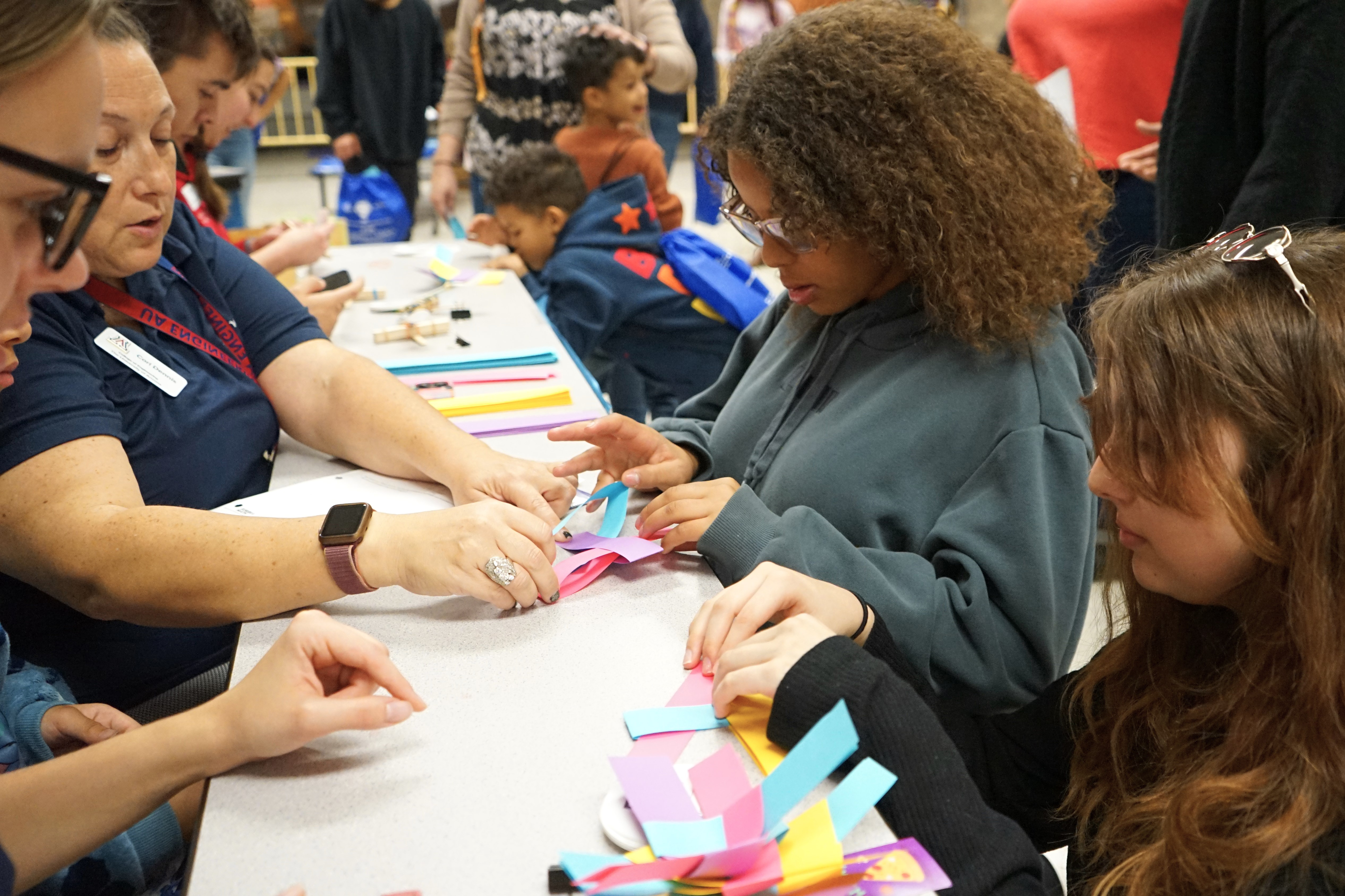 Two girls work on making paper crafts