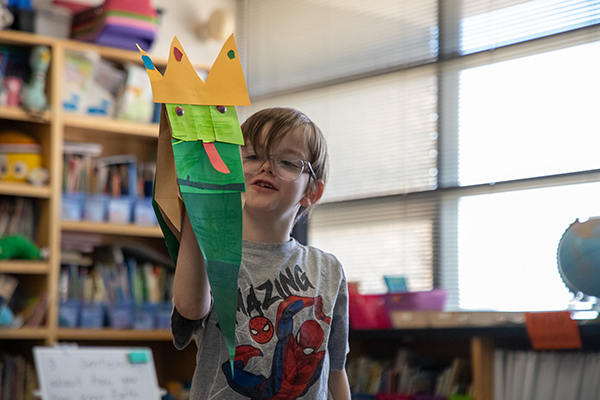 A boy shows off his snake made with paper bags